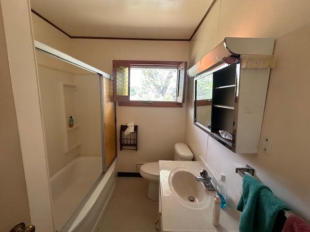 21 Glen Cir, Babbitt, MN 55706 - full bathroom featuring toilet, vanity, enclosed tub / shower combo, and baseboards