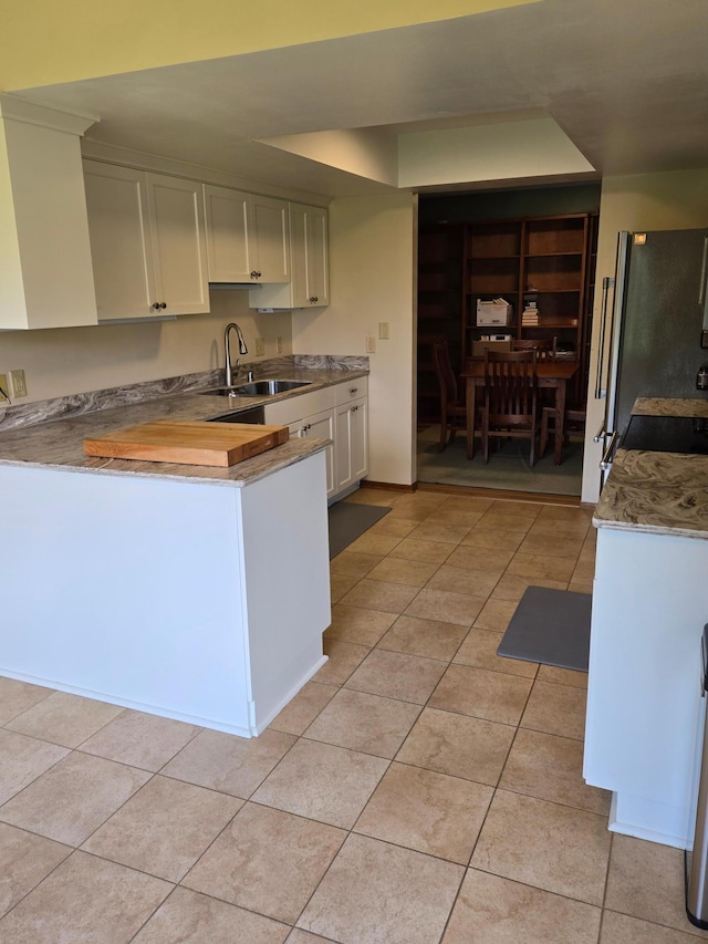 1924 Greenfield Ln SW Unit 201, Rochester, MN 55902 - kitchen with a sink, light tile patterned floors, white cabinets, freestanding refrigerator, and light countertops