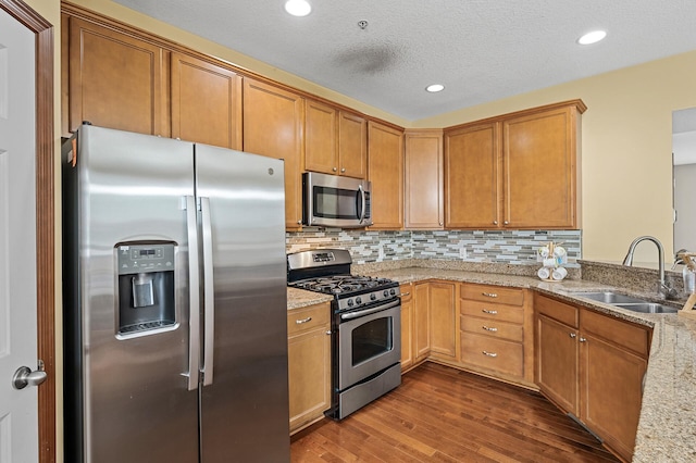 1949 Commonwealth Blvd Unit 2, Chanhassen, MN 55317 - kitchen featuring appliances with stainless steel finishes, dark wood-style floors, light stone counters, decorative backsplash, and brown cabinets