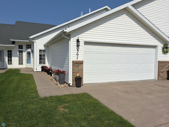 3307 38th St S, Moorhead, MN 56560 - view of property exterior featuring driveway, brick siding, a garage, and a yard