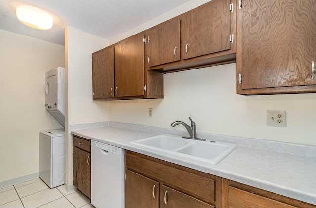 7880 Rimbley Rd, Woodbury, MN 55125 - kitchen with white dishwasher, estacked washer and dryer, light tile patterned flooring, and light countertops