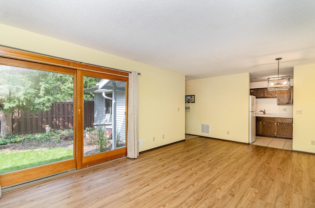 7880 Rimbley Rd, Woodbury, MN 55125 - unfurnished living room featuring light wood-style floors and a sink