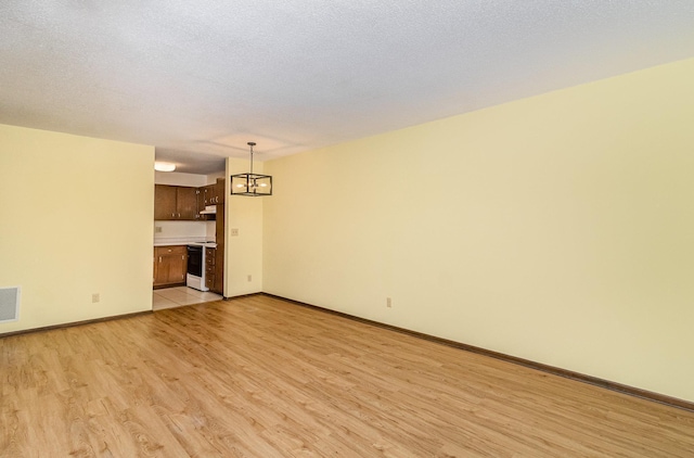 7880 Rimbley Rd, Woodbury, MN 55125 - unfurnished living room with light wood finished floors and a chandelier