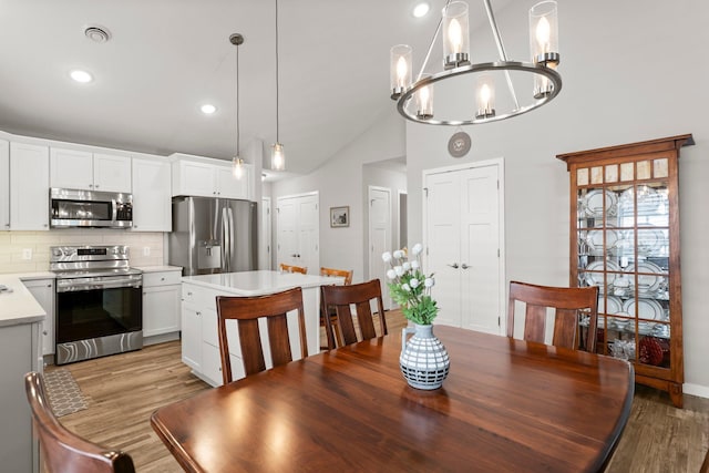 11164 184th Cir NW, Elk River, MN 55330 - dining area featuring light wood-style floors, a chandelier, recessed lighting, and high vaulted ceiling