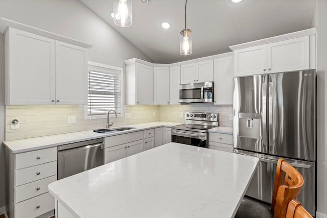 11164 184th Cir NW, Elk River, MN 55330 - kitchen with stainless steel appliances, lofted ceiling, a kitchen island, decorative backsplash, and white cabinetry