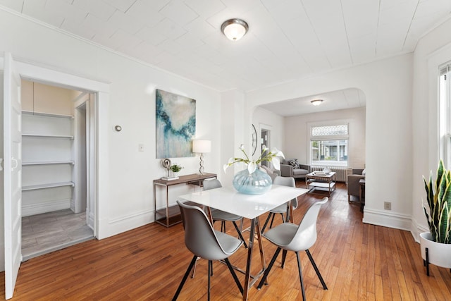 786 Iglehart Ave, Saint Paul, MN 55104 - dining space featuring ornamental molding, hardwood / wood-style flooring, arched walkways, and radiator