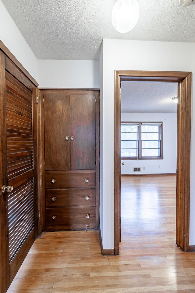 7533 16th Ave S, Richfield, MN 55423 - hallway featuring light wood-style floors, a textured ceiling, and baseboards