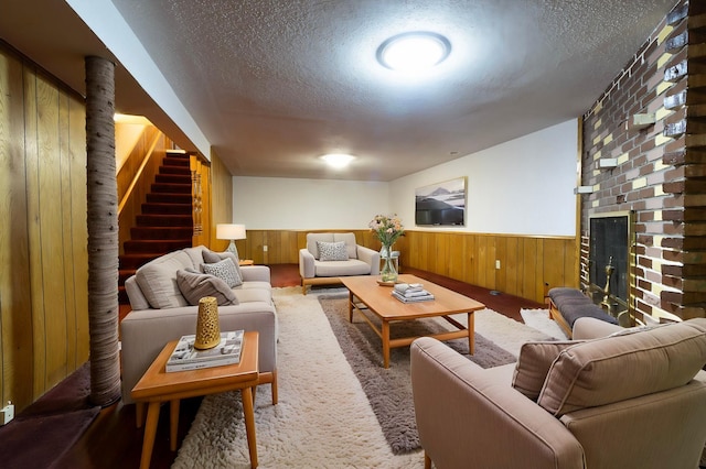 7533 16th Ave S, Richfield, MN 55423 - living area featuring a wainscoted wall, wooden walls, a textured ceiling, stairs, and a brick fireplace