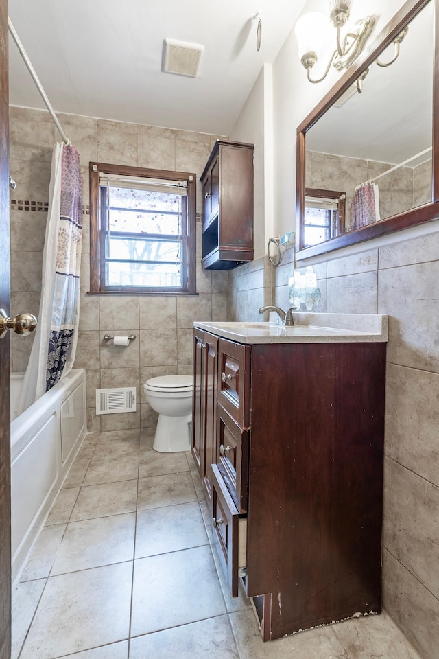 7533 16th Ave S, Richfield, MN 55423 - bathroom featuring tile walls, vanity, toilet, shower / tub combo with curtain, and tile patterned flooring