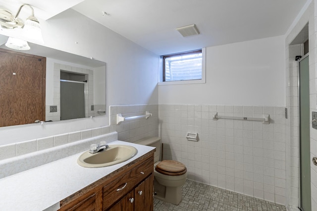 7533 16th Ave S, Richfield, MN 55423 - bathroom with toilet, a shower stall, tile walls, vanity, and tile patterned flooring