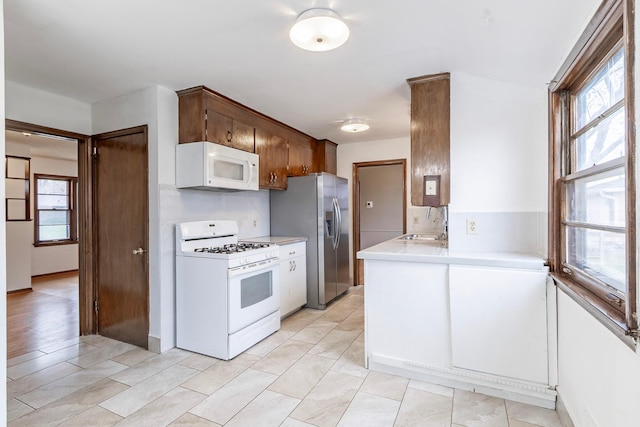 7533 16th Ave S, Richfield, MN 55423 - kitchen with white appliances, light countertops, healthy amount of natural light, and a sink