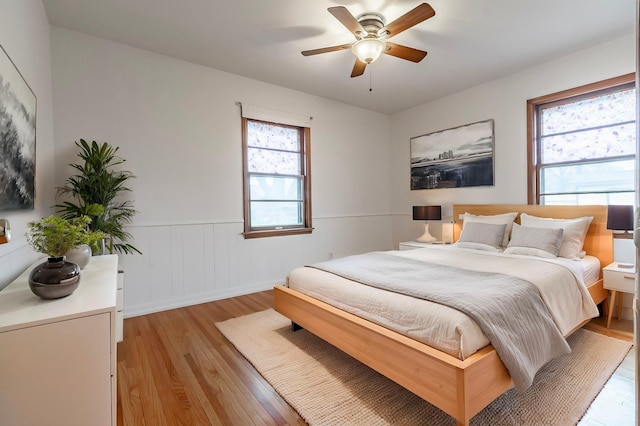 7533 16th Ave S, Richfield, MN 55423 - bedroom with light wood-style flooring, a wainscoted wall, and a ceiling fan