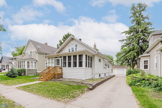 1023 12th St N, Fargo, ND 58102 - bungalow-style home with a chimney, an outdoor structure, a garage, and a front lawn