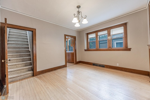 1023 12th St N, Fargo, ND 58102 - unfurnished room featuring ornamental molding, a chandelier, light wood-style flooring, and stairway