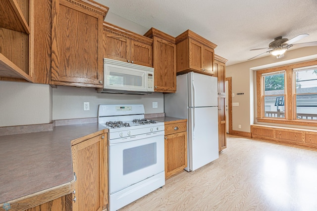 1023 12th St N, Fargo, ND 58102 - kitchen featuring white appliances, ceiling fan, brown cabinets, a textured ceiling, and light wood-style floors