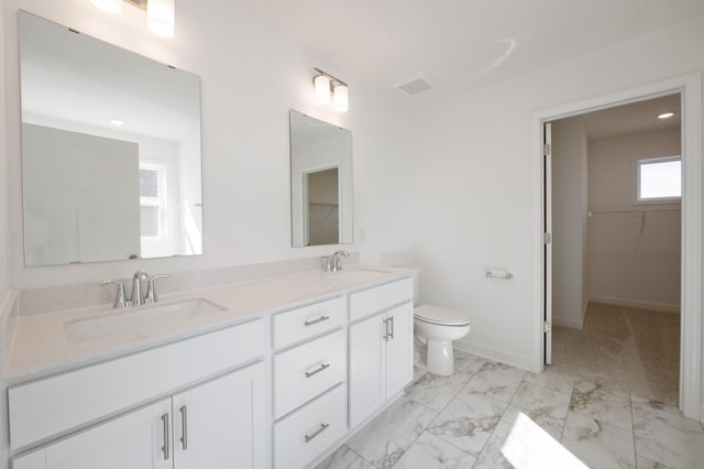 2508 Downing Ave, Shakopee, MN 55379 - bathroom with double vanity, toilet, marble look tiles, a spacious closet, and baseboards