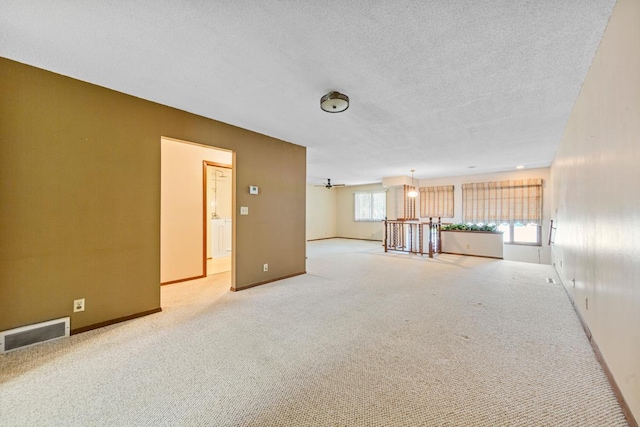 635 5th St, Windom, MN 56101 - empty room featuring light carpet, a textured ceiling, and a chandelier