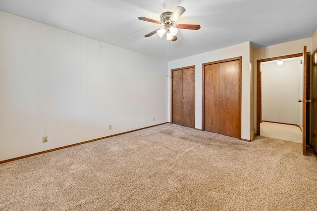 635 5th St, Windom, MN 56101 - unfurnished bedroom with two closets, carpet flooring, and a ceiling fan