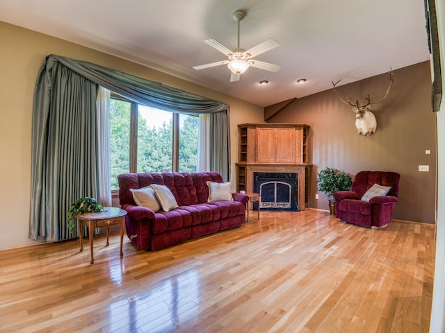 22152 Polaris Rd NW, Puposky, MN 56667 - living area featuring light wood-style flooring, a fireplace with flush hearth, a ceiling fan, and vaulted ceiling