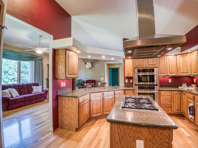 22152 Polaris Rd NW, Puposky, MN 56667 - kitchen with island range hood, stainless steel appliances, light wood-style floors, a ceiling fan, and a high ceiling
