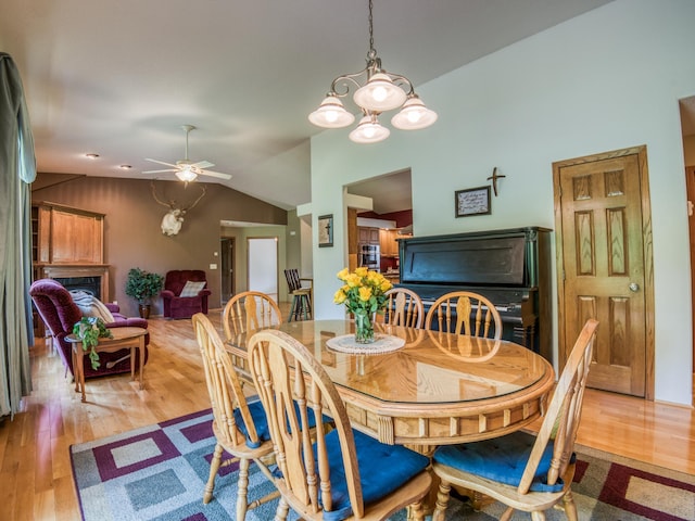 22152 Polaris Rd NW, Puposky, MN 56667 - dining space with vaulted ceiling, light wood finished floors, a ceiling fan, and a chandelier
