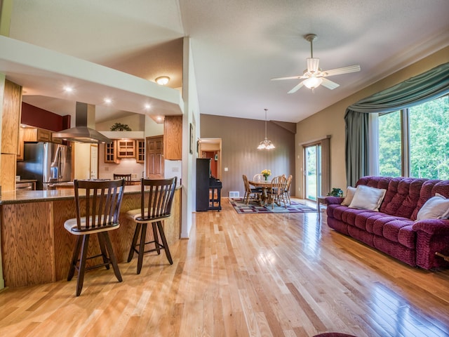 22152 Polaris Rd NW, Puposky, MN 56667 - kitchen featuring island exhaust hood, stainless steel fridge with ice dispenser, plenty of natural light, light wood finished floors, and lofted ceiling