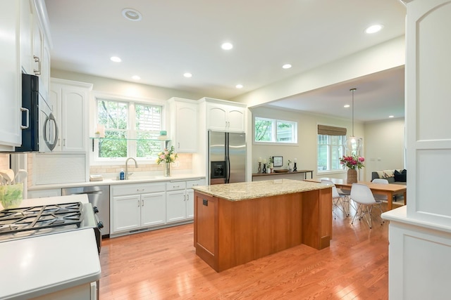3543 Eben Way, Stillwater, MN 55082 - kitchen featuring stainless steel appliances, a kitchen island, a sink, tasteful backsplash, and white cabinetry