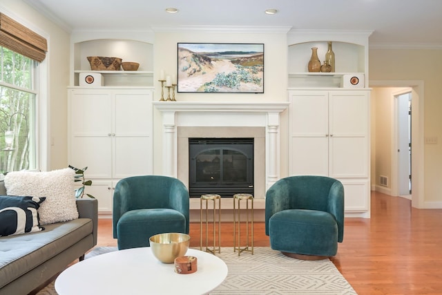 3543 Eben Way, Stillwater, MN 55082 - living room with light wood-type flooring, a glass covered fireplace, ornamental molding, built in shelves, and baseboards