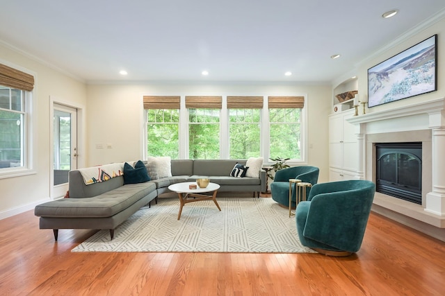 3543 Eben Way, Stillwater, MN 55082 - living area featuring wood finished floors, a glass covered fireplace, ornamental molding, baseboards, and recessed lighting