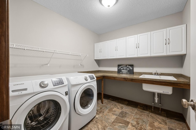 5261 Fenson Ct N, Hugo, MN 55038 - laundry area featuring washer and clothes dryer, dark stone finish flooring, cabinet space, and a textured ceiling