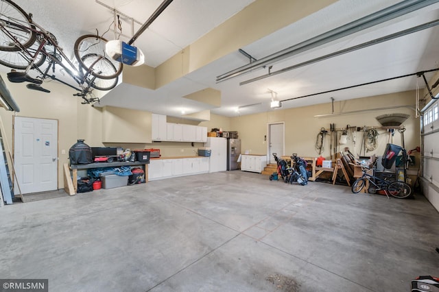 5261 Fenson Ct N, Hugo, MN 55038 - garage with a garage door opener and stainless steel fridge with ice dispenser