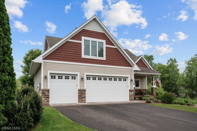5261 Fenson Ct N, Hugo, MN 55038 - craftsman inspired home featuring driveway, stone siding, a porch, and roof with shingles