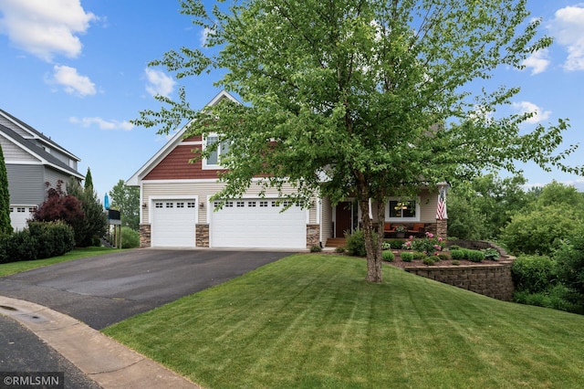 5261 Fenson Ct N, Hugo, MN 55038 - view of front of property with stone siding, asphalt driveway, a front lawn, and covered porch