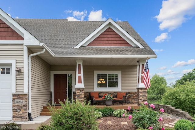 5261 Fenson Ct N, Hugo, MN 55038 - view of front facade with covered porch, roof with shingles, and stone siding