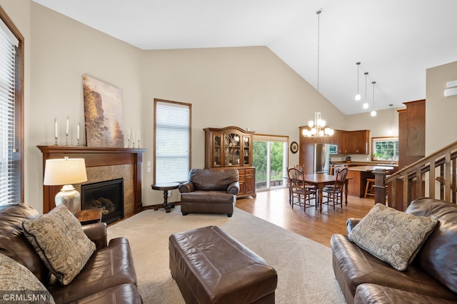5261 Fenson Ct N, Hugo, MN 55038 - living room with a chandelier, high vaulted ceiling, a tiled fireplace, and light wood-style flooring