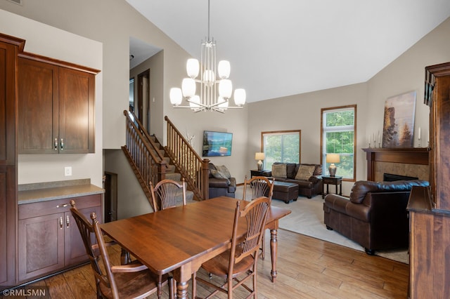 5261 Fenson Ct N, Hugo, MN 55038 - dining room with light wood finished floors, lofted ceiling, a fireplace, a chandelier, and stairway
