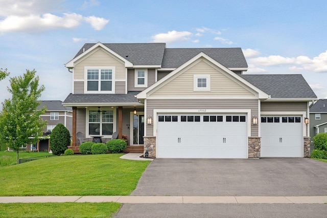 17552 57th St NE, Otsego, MN 55374 - craftsman house featuring driveway, a porch, an attached garage, a front yard, and stone siding