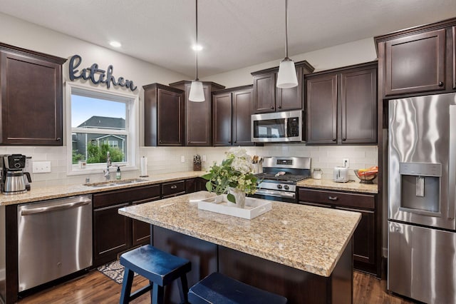 17552 57th St NE, Otsego, MN 55374 - kitchen with appliances with stainless steel finishes, dark brown cabinets, dark wood-style flooring, a kitchen bar, and recessed lighting