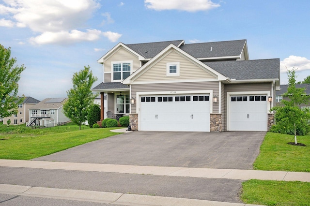 17552 57th St NE, Otsego, MN 55374 - view of front of home with asphalt driveway, stone siding, a front lawn, roof with shingles, and an attached garage