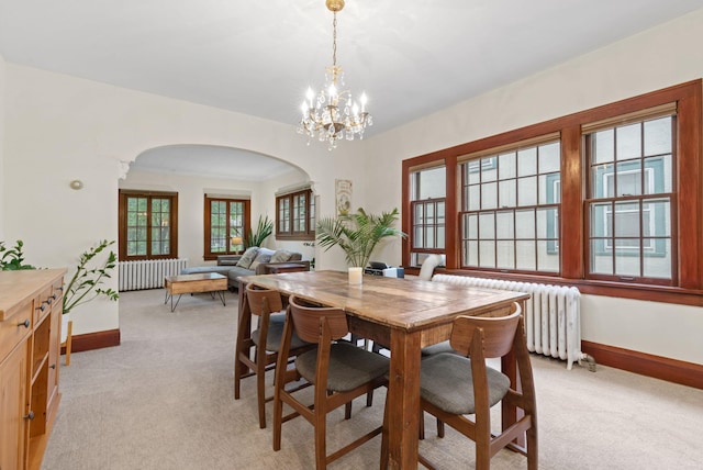 952 Goodrich Ave, Saint Paul, MN 55105 - dining room featuring radiator heating unit, arched walkways, light carpet, and a chandelier
