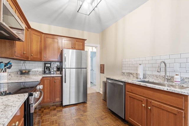 952 Goodrich Ave, Saint Paul, MN 55105 - kitchen featuring appliances with stainless steel finishes, extractor fan, decorative backsplash, brown cabinetry, and light stone counters