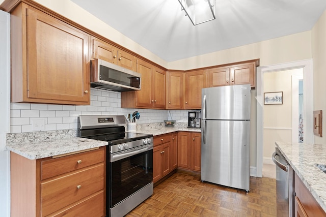 952 Goodrich Ave, Saint Paul, MN 55105 - kitchen featuring stainless steel appliances, tasteful backsplash, light stone countertops, and brown cabinets