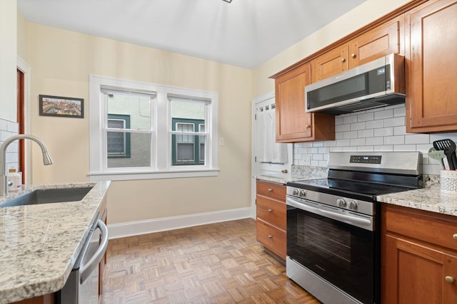952 Goodrich Ave, Saint Paul, MN 55105 - kitchen featuring stainless steel appliances, decorative backsplash, brown cabinets, and light stone countertops