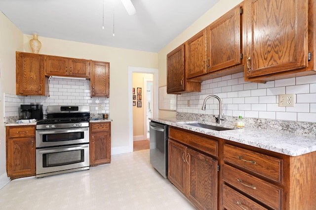 952 Goodrich Ave, Saint Paul, MN 55105 - kitchen featuring stainless steel appliances, decorative backsplash, brown cabinetry, and light stone countertops