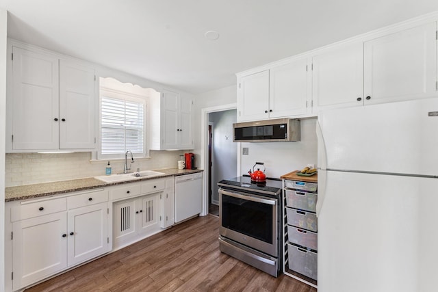 5605 Logan Ave S, Minneapolis, MN 55419 - kitchen featuring appliances with stainless steel finishes, wood finished floors, white cabinets, and tasteful backsplash
