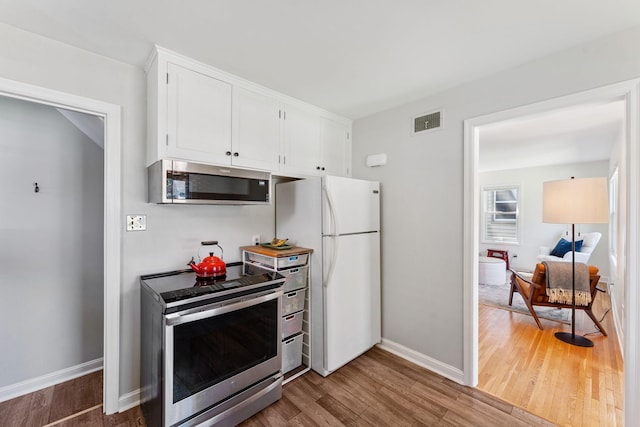5605 Logan Ave S, Minneapolis, MN 55419 - kitchen featuring appliances with stainless steel finishes, wood finished floors, and white cabinets