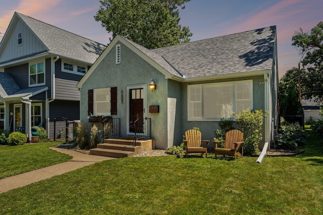 5605 Logan Ave S, Minneapolis, MN 55419 - view of front facade with a shingled roof, a yard, board and batten siding, and stucco siding