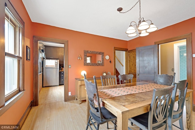 5116 28th Ave S, Minneapolis, MN 55417 - dining room featuring healthy amount of natural light, a chandelier, light wood finished floors, and baseboards