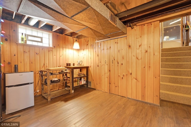 5116 28th Ave S, Minneapolis, MN 55417 - below grade area featuring freestanding refrigerator, wood finished floors, stairway, and wood walls
