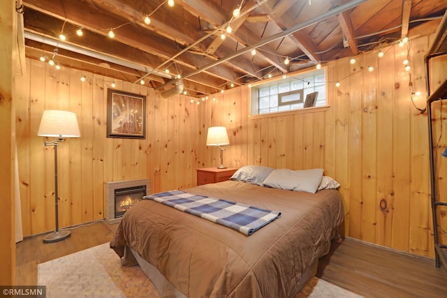 5116 28th Ave S, Minneapolis, MN 55417 - bedroom featuring wood finished floors, a glass covered fireplace, and wood walls